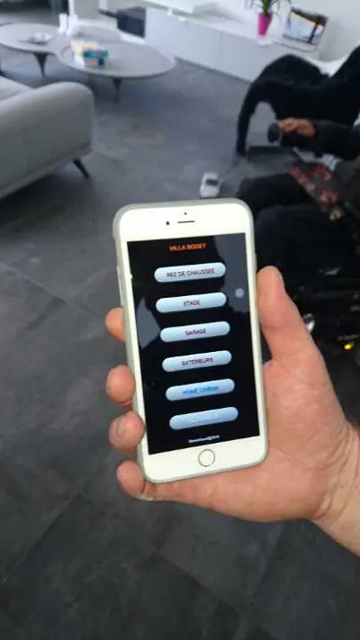 Main tenant smartphone avec appli domotique.