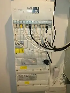 Tableau électrique avec câbles et disjoncteurs.