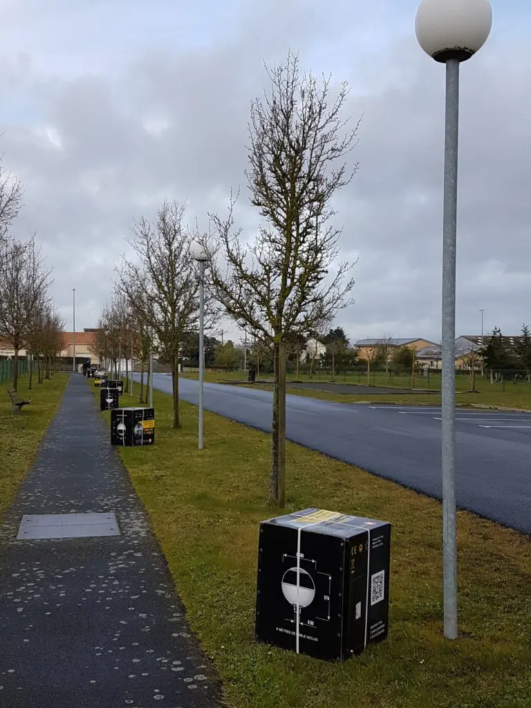 Rangée de boîtes à lampadaires sur un trottoir.