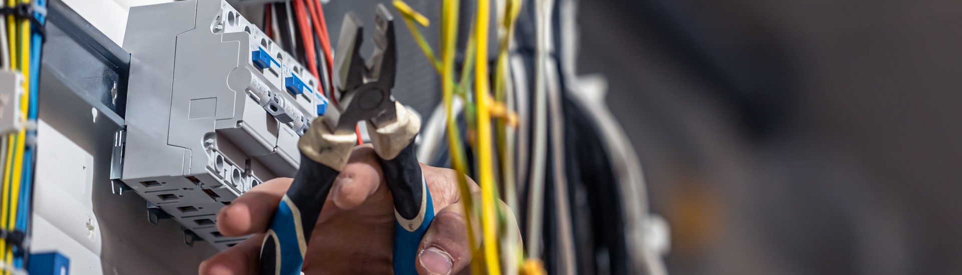 Électricien travaillant sur un panneau de câblage.