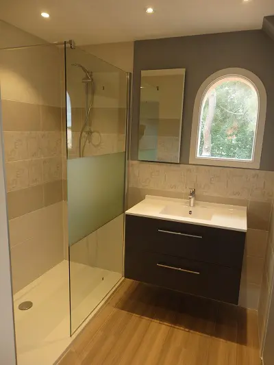 Salle de bain moderne avec douche et lavabo design.