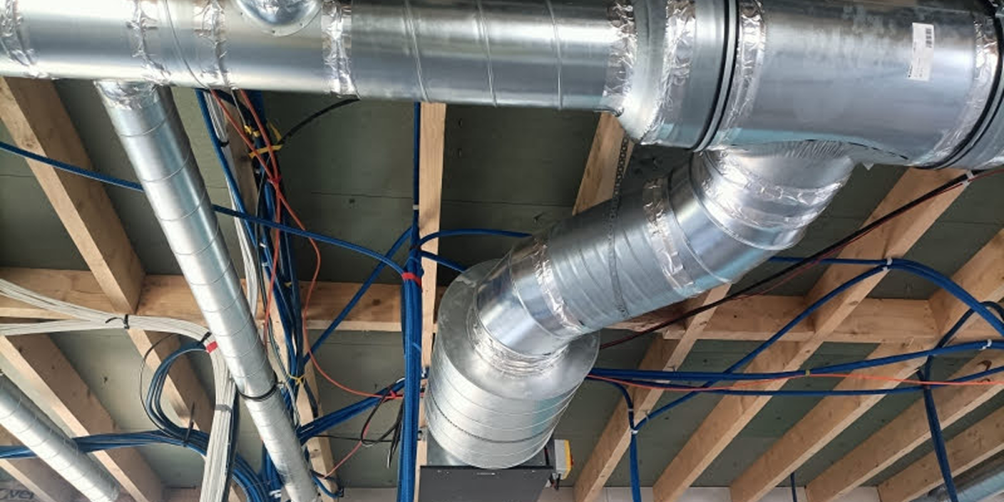 Conduits métalliques et câbles au plafond.