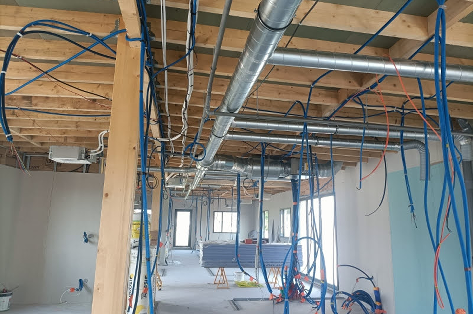 Chantier avec câbles et conduits apparents.