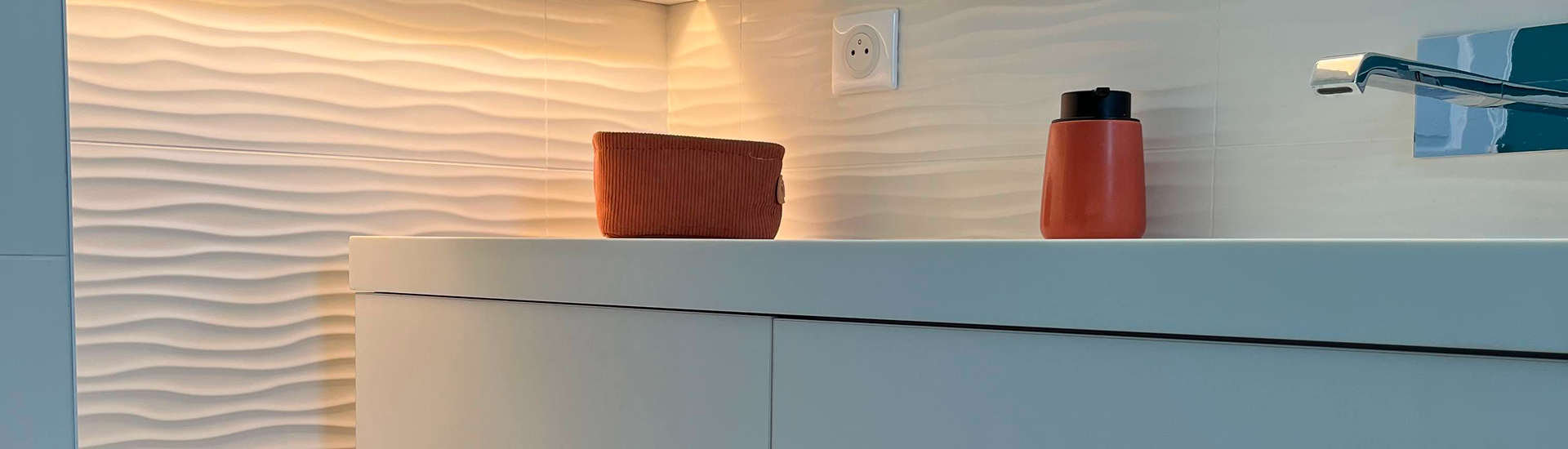 Salle de bain avec carrelage ondulé et robinet moderne.