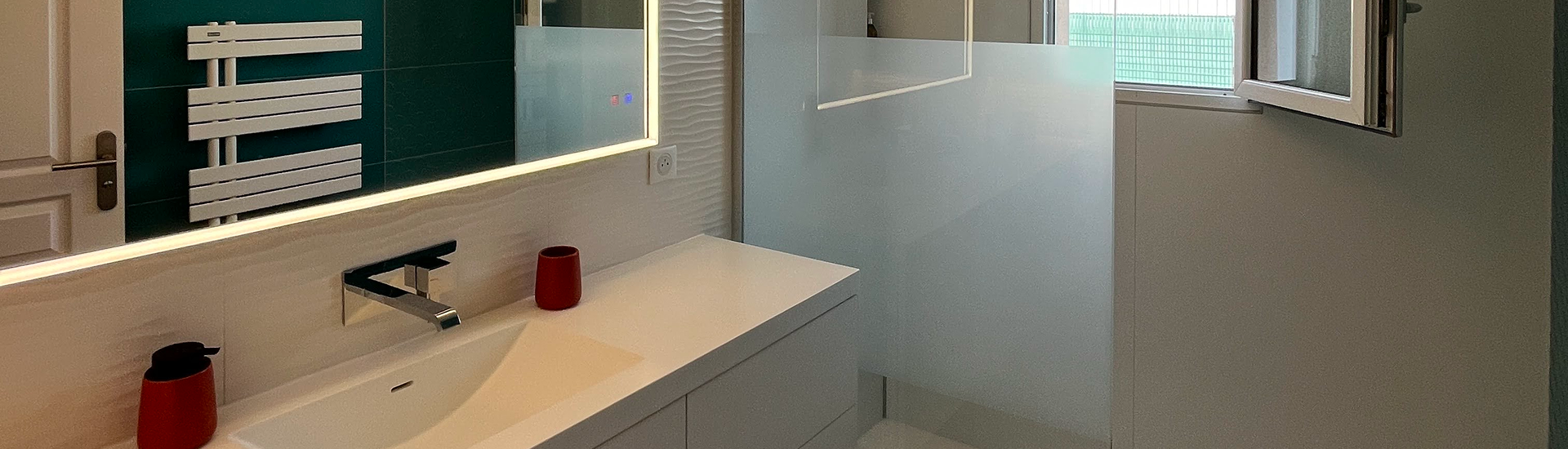 Salle de bain moderne avec lavabo et miroir lumineux.