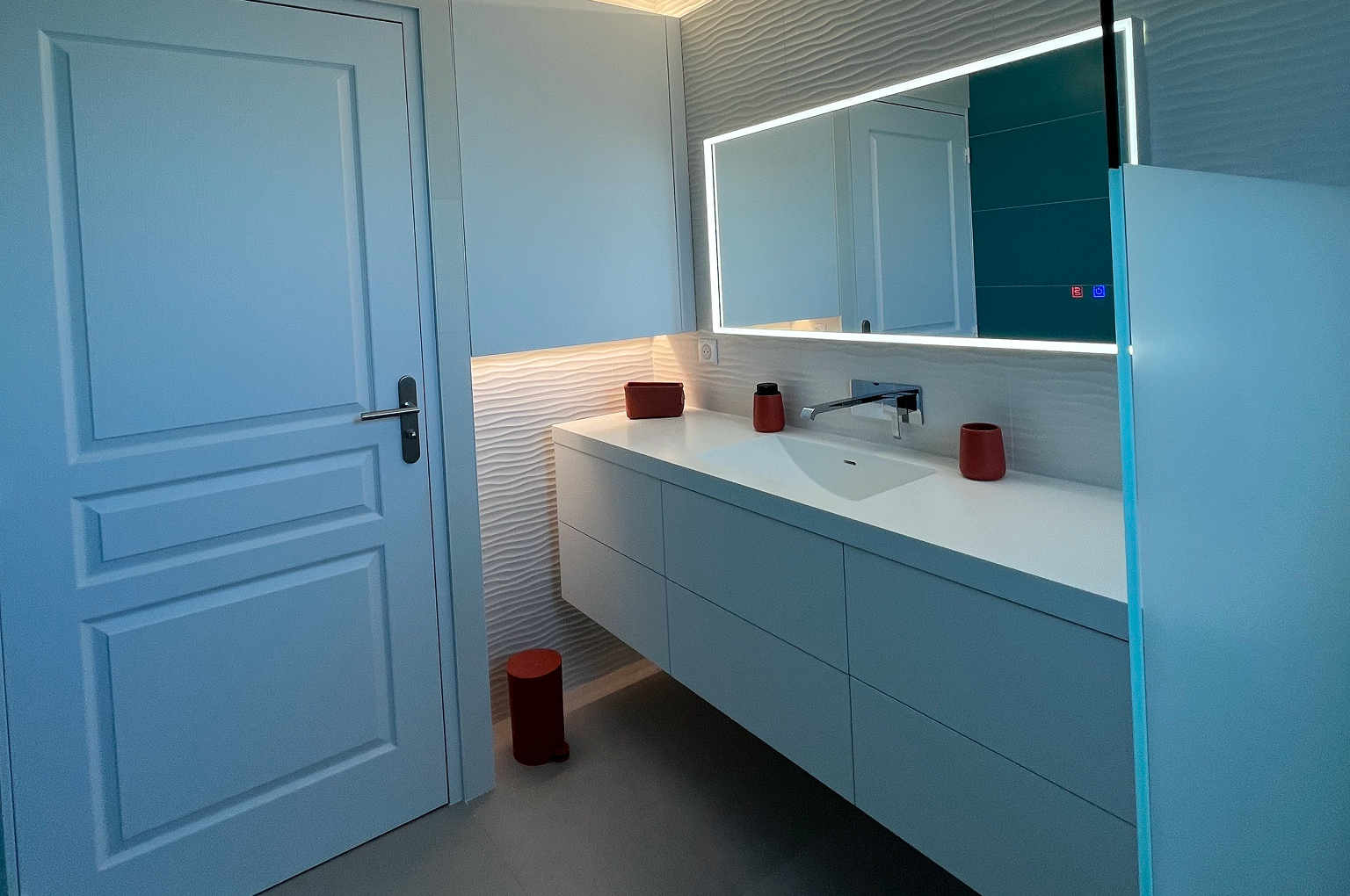 Salle de bain moderne avec miroir éclairé.